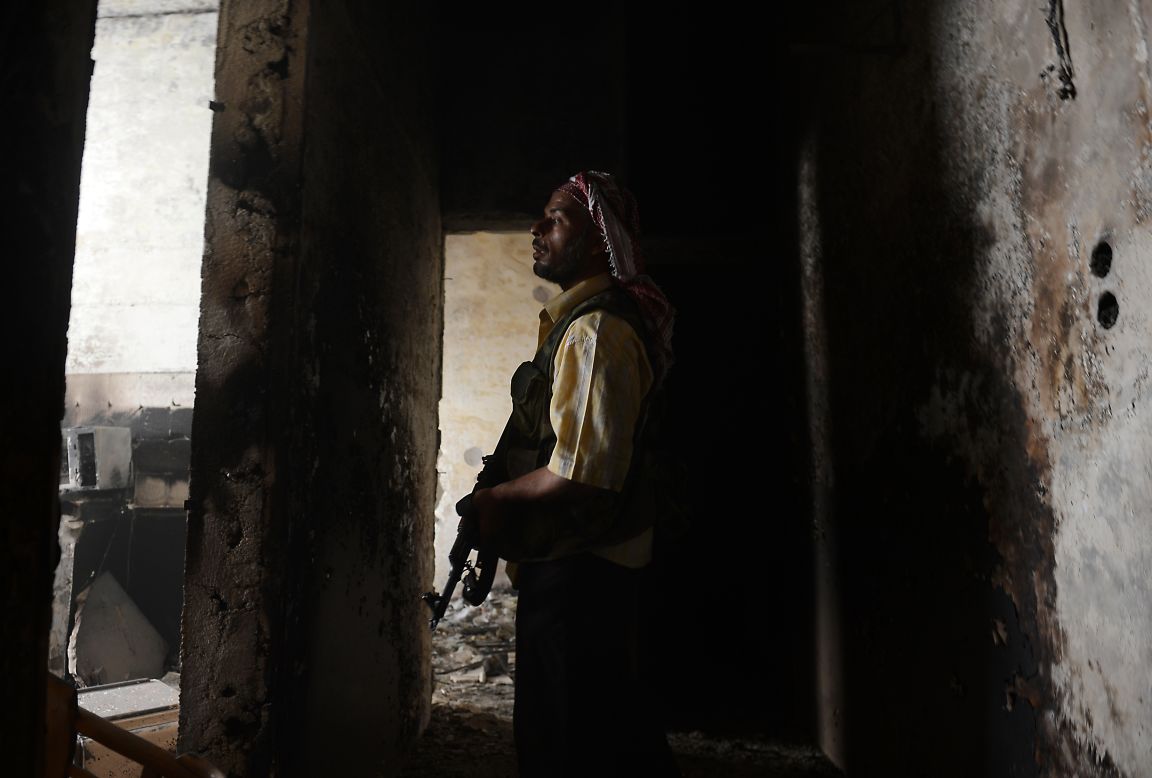 A Syrian rebel takes position during clashes with government forces in Aleppo on Friday.