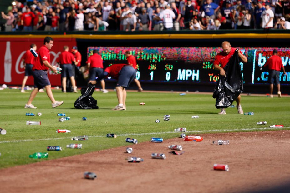 The grounds crew cleans up bottles and cups thrown by fans.