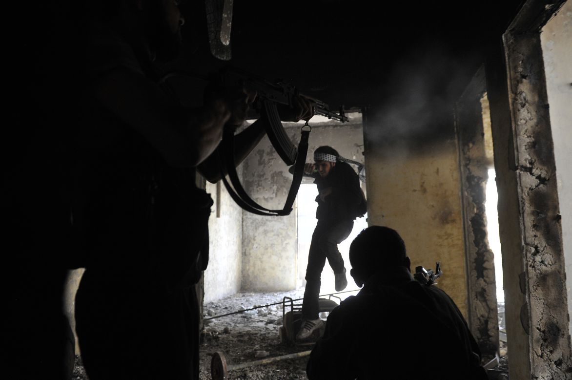 Syrian rebels take up positions inside a building during clashes with government forces in Aleppo on Saturday, October 6. 