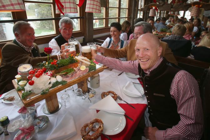 Visitors drink beer while rain falls on the Oktoberfest festival fairground on Sunday.