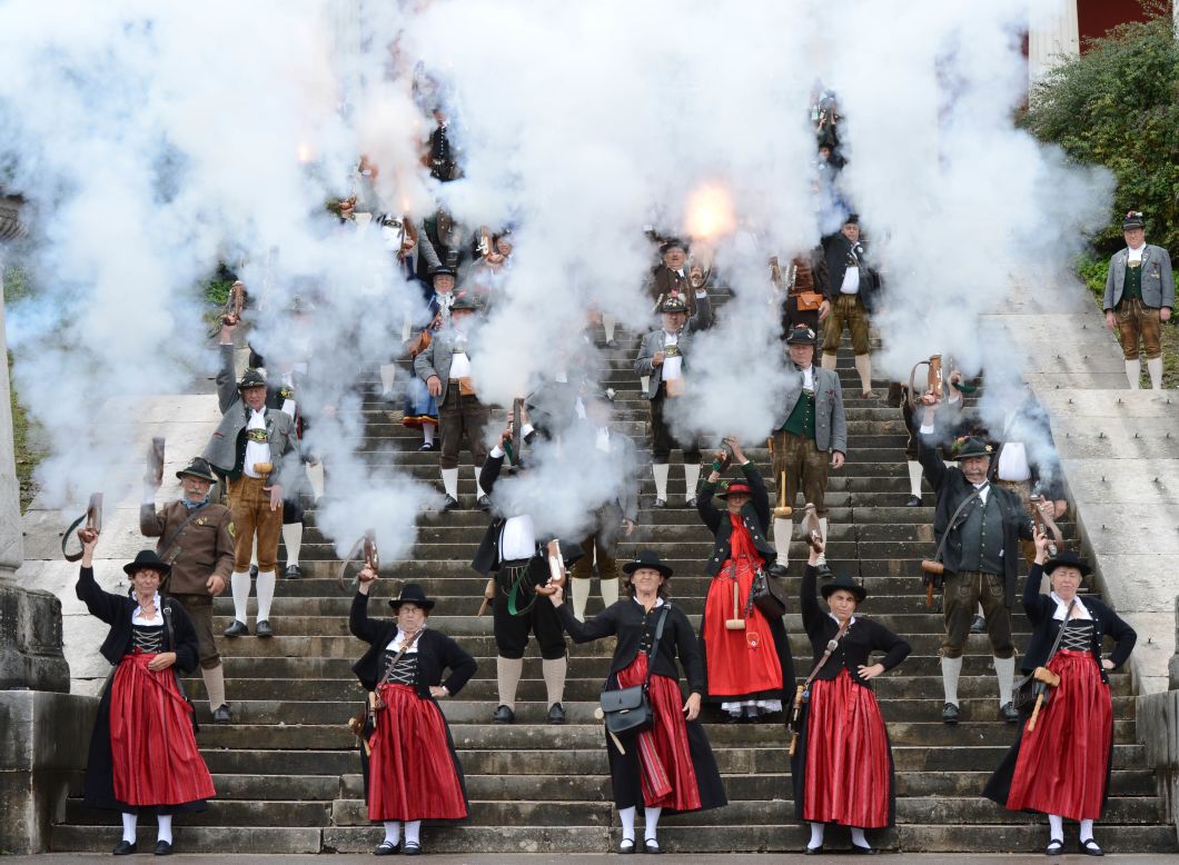 People in traditional Bavarian garb fire a salute Sunday on the steps of the Bavaria monument.
