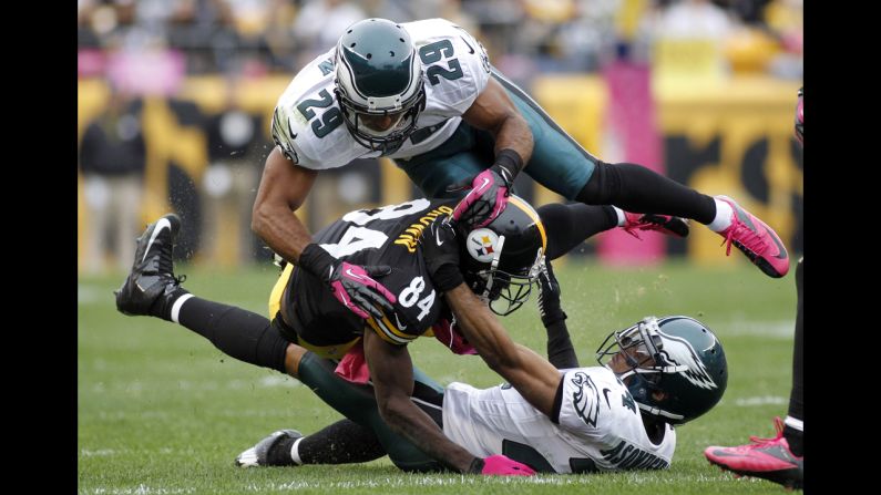 No. 29 Nate Allen and No. 24 Nnamdi Asomugha of the Eagles tackle Antonio Brown.