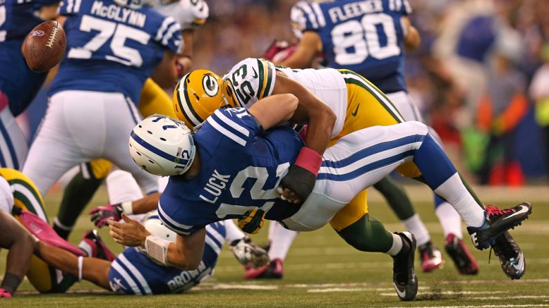 Andrew Luck of the Indianapolis Colts loses the ball as he is hit by Nick Perry of the Green Bay Packers.