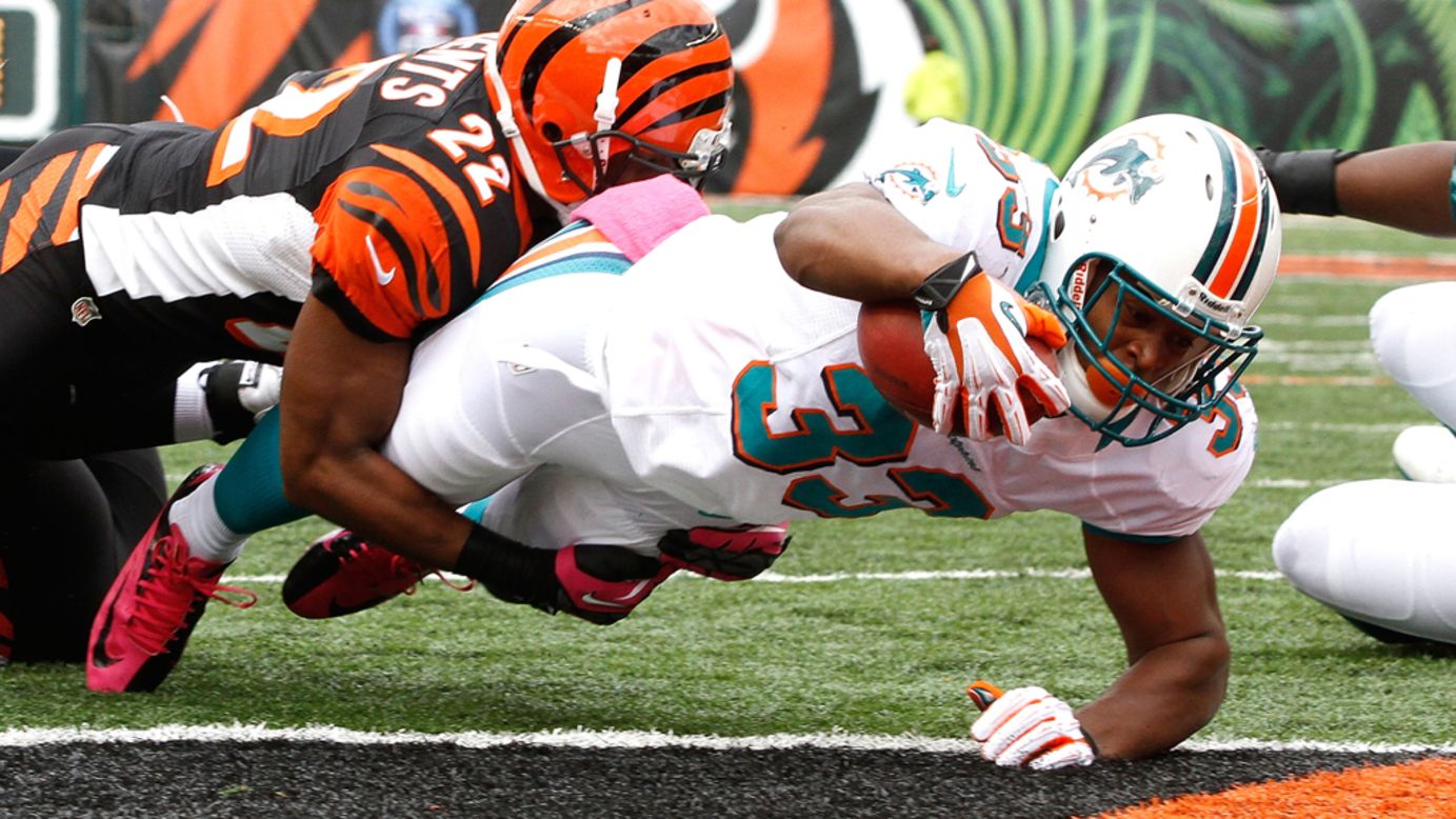 Daniel Thomas of the Dolphins dives into the end zone to score a touchdown against the Bengals.