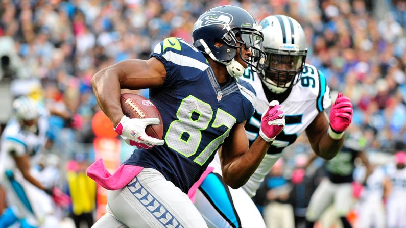 Ben Obomanu of the Seahawks is chased by Alan Branch of the Panthers as he turns upfield on a reverse.
