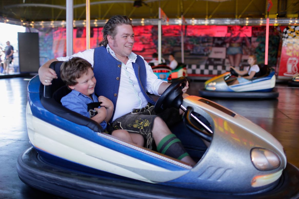 A father and son dressed in traditional Bavarian clothing ride in a bumper car on Friday.