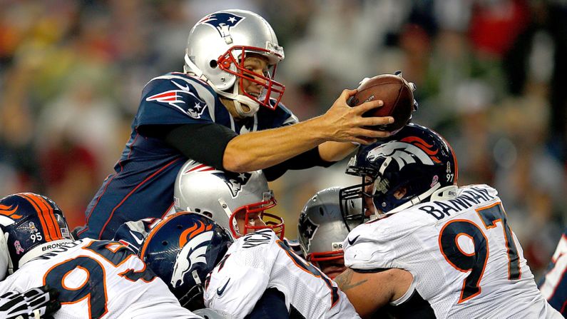 Quarterback Tom Brady of the New England Patriots leaps for a touchdown against the Denver Broncos on Sunday at Gillette Stadium in Foxboro, Massachusetts.
