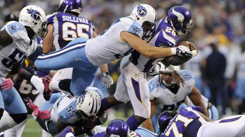 Karl Klug of the Tennessee Titans tackles Adrian Peterson of the Minnesota Vikings in the second quarter on Sunday.