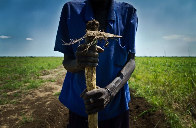 A farmer holds a plow  near the Sudan-South Sudan border. 