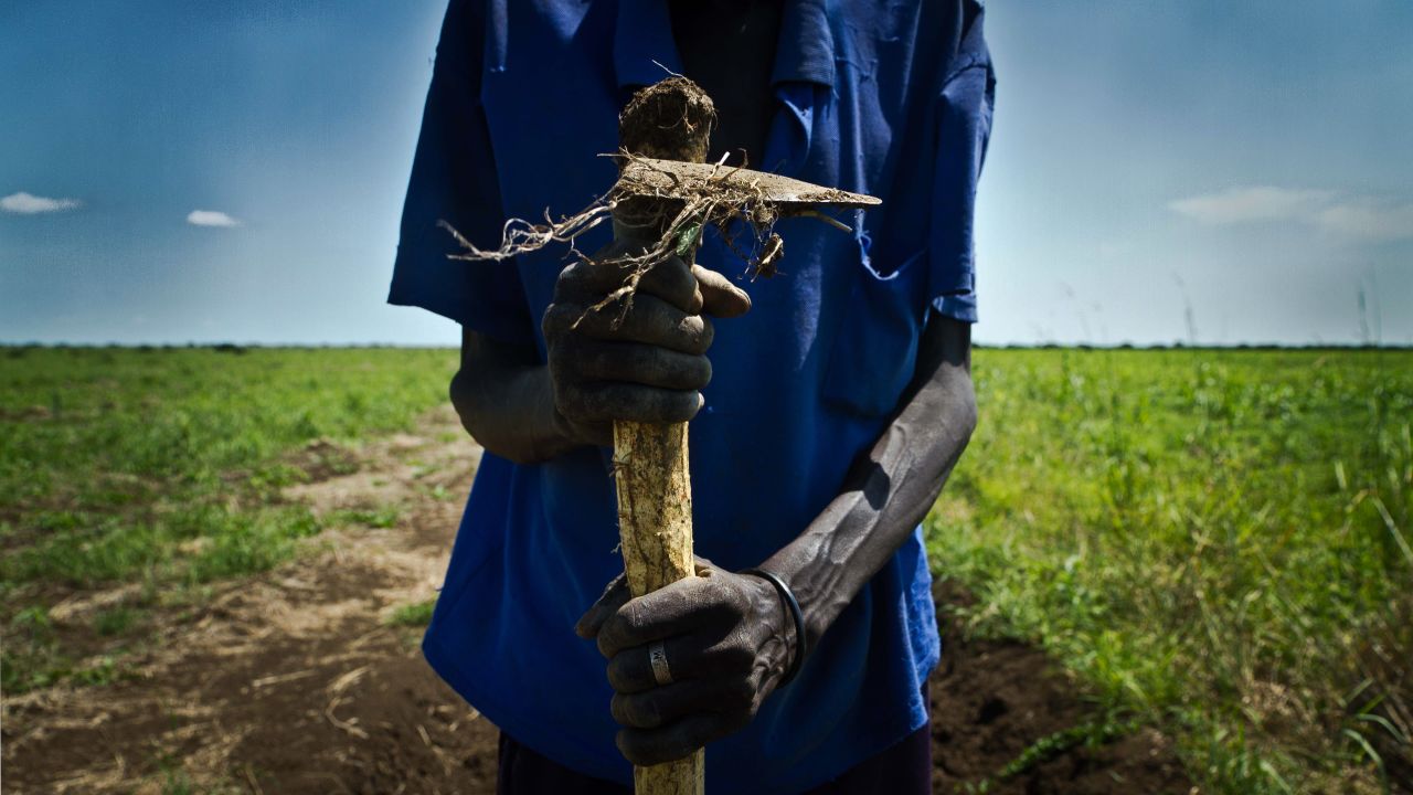 A South Sudanese farmer holds a plow in Renk, a city near the Sudan border. The two nations are hashing out border issues.