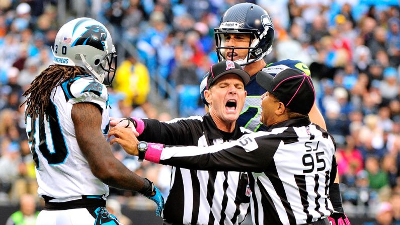 Officials break up a skirmish Sunday between Charles Godfrey of the Carolina Panthers and Gary Barnidge of the Seattle Seahawks.
