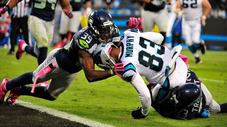 Brandon Browner, left, and Marcus Trufant of the Seahawks tackle Louis Murphy of the Panthers just short of the goal line Sunday.