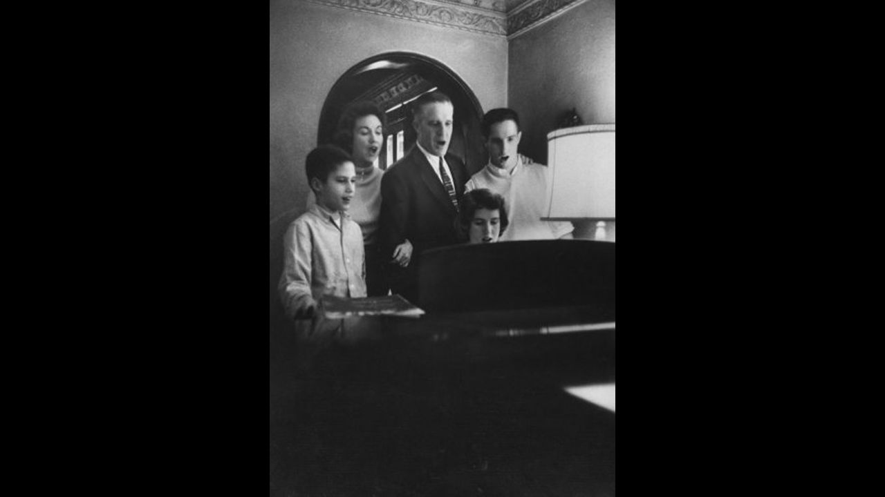The Romney family, from left, Mitt, mother Lenore, father George, sister Jane and brother Scott get together at the piano for a hymn in 1958. Mitt Romney grew up in a Mormon household.