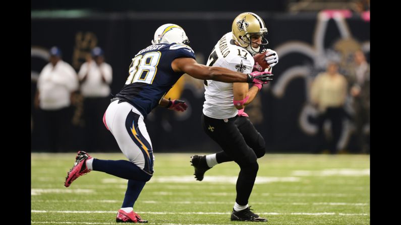 Saints wide receiver Greg Camarillo carries the ball as Marcus Gilchrist of the Chargers tries to make a tackle on Sunday.