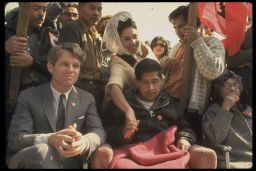 Robert F. Kennedy sits next to Cesar Chavez, looking very weak after prolonged hunger strike, during a rally in support of the United Farm Workers Union.