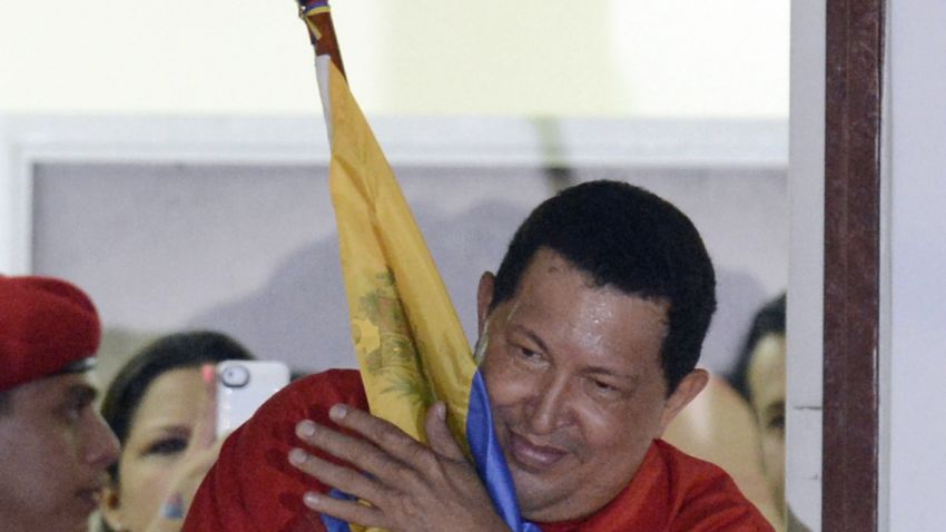 Venezuelan President Hugo Chavez embraces a Venezuelan flag while speaking to supporters after receiving news of his reelection in Caracas.