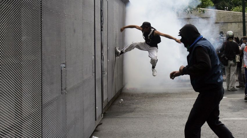 ATHENS, GREECE - OCTOBER 09: Demonstrators clash with riot police during a protest against the visit to Greece by Germany's Chancellor Angela Merkel October 9, 2012 in Athens, Germany. Germany's Chancellor Angela Merkel arrived in Greece on her first visit since Europe's debt crisis erupted here three years ago, braving protests to deliver a message of support to a nation hammered by recession and fighting to stay in the euro. (Photo by Milos Bicanski/Getty Images)