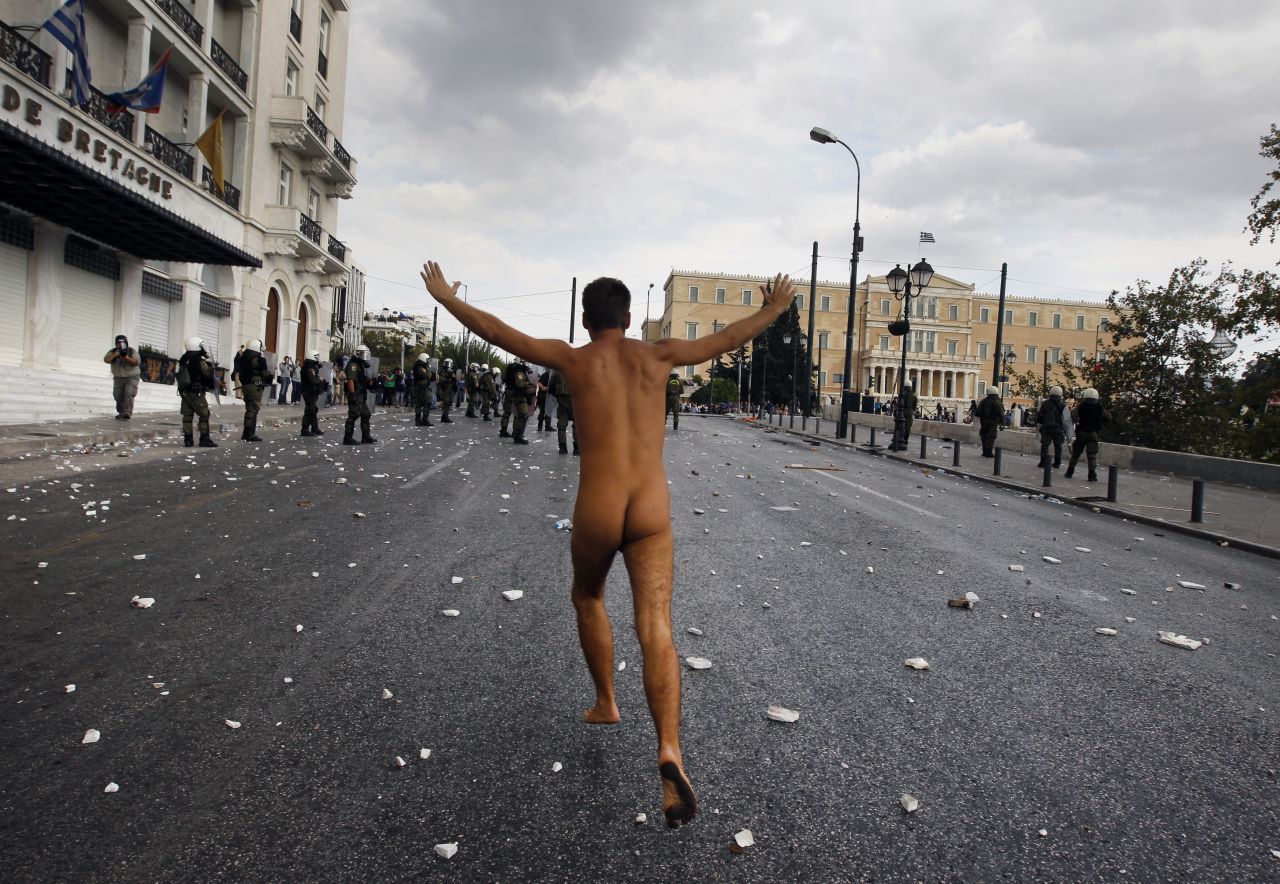 A naked protester runs past the parliament in Syntagma Square.