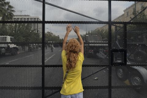 A protester stands against a barrier erected to protect the Greek parliament.