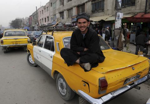 An Afghan taxi driver sits on the back of a Russian-made cab in Kabul in 2011. Many Afghans fear the war here is dropping down America's list of priorities. 