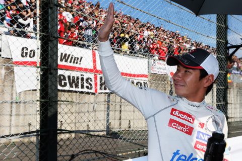 Kobayashi waves to an adoring crowd as he prepares to drive in his maiden Japanese Grand Prix. 