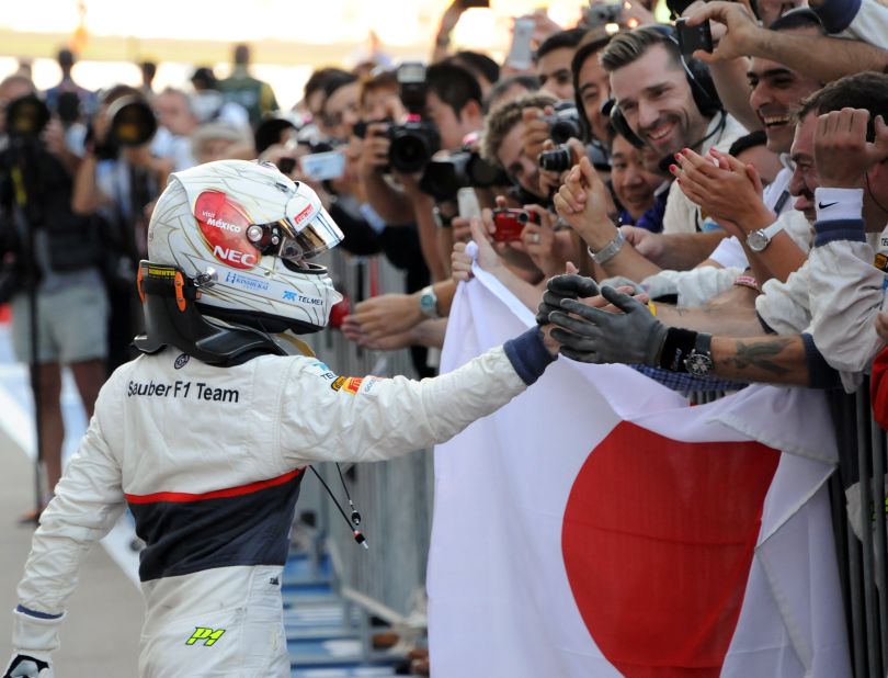 Kobayashi celebrates his historic podium placing with members of the Sauber team. 