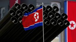 A North Korean flag flies before missiles displayed during a military parade to mark 100 years since the birth of the country's founder Kim Il-Sung in Pyongyang on April 15, 2012. 