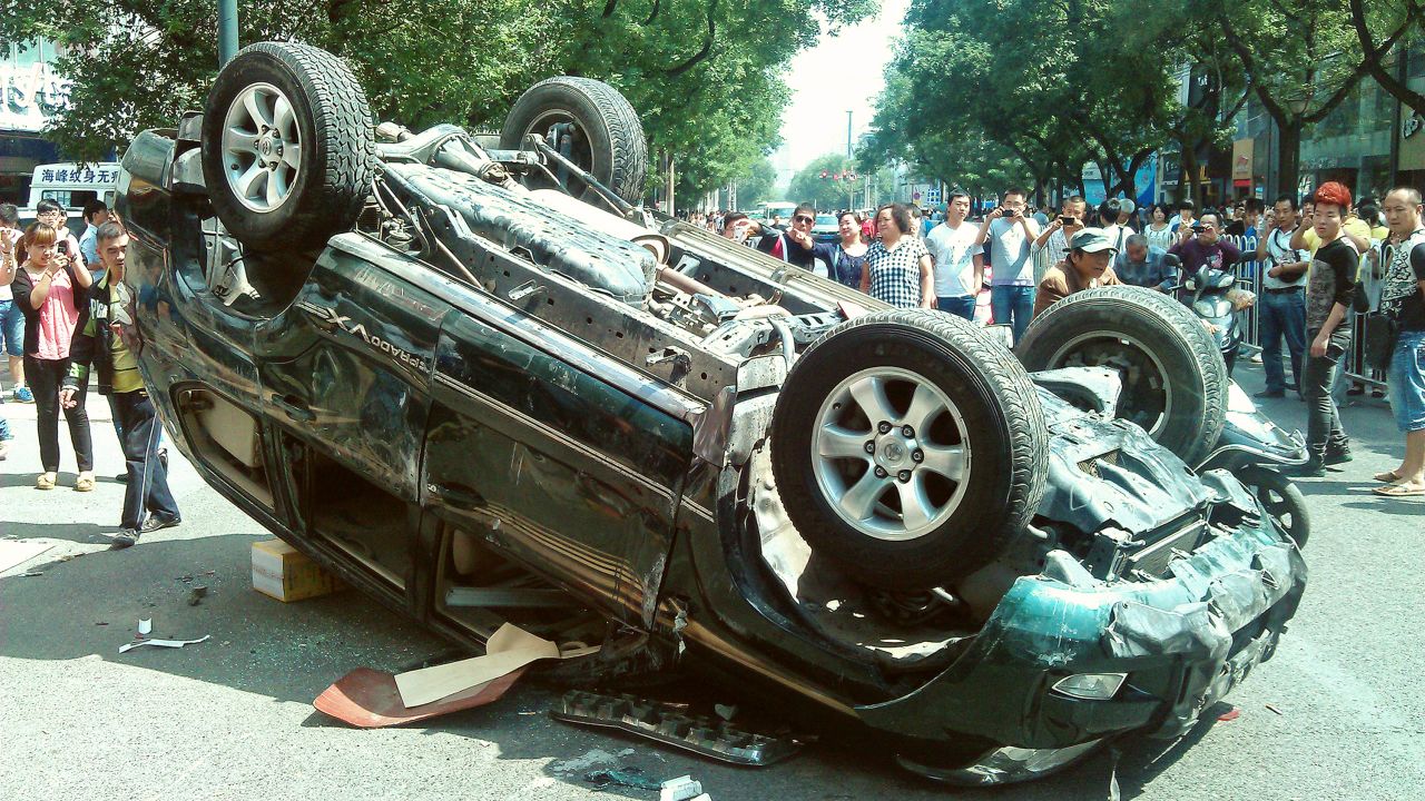 People taking pictures of a Japanese-brand car damaged during a protest against Japan in the Chinese city of Xian in 2012.