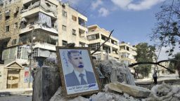A portrait of Syrian President Bashar al-Assad defaced to look like a devil is placed on rubble along a street during clashes with government forces in a Saif al-Dawla district of the northern city of Aleppo on October 9, 2012. Syrian rebels overrun Maaret al-Numan, a strategic Idlib province town on the highway linking Damascus with second city Aleppo, as fighting rages after twin suicide bomb attacks on an air force compound near Damascus. AFP PHOTO/Tauseef MUSTAFA (Photo credit should read TAUSEEF MUSTAFA/AFP/GettyImages) 