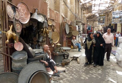 Iraqi women walk past vendors at the Safafir Market in Baghdad on April 4, 2012. Although violence is down in recent years, Meyer says kidnapping and assassinations are part of daily life in the capital.