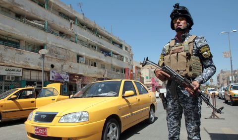 An Iraqi policeman stands guard at a checkpoint in central Baghdad. It has been 10 months since U.S. combat troops left, but it is far from peace time in Iraq.