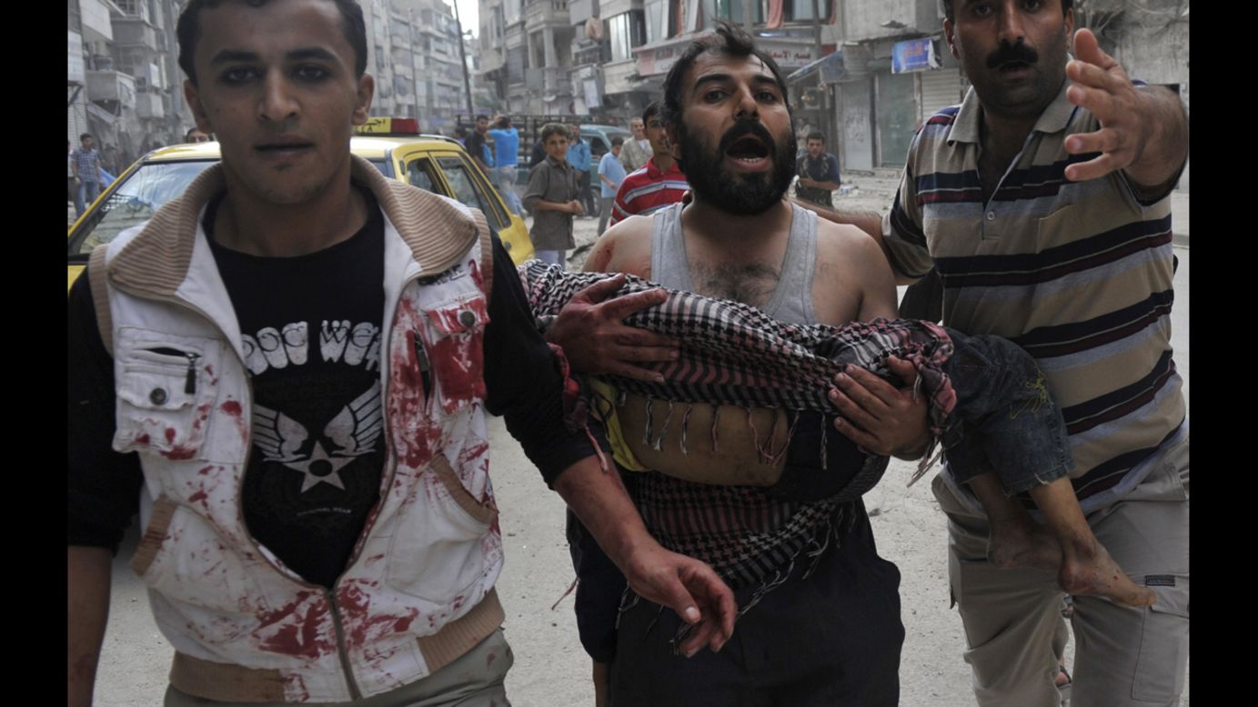 A Syrian man carries the body of his 5-year-old son, Mohammed Mustafa, outside a hospital after shelling by Syrian government forces in Aleppo on Tuesday.