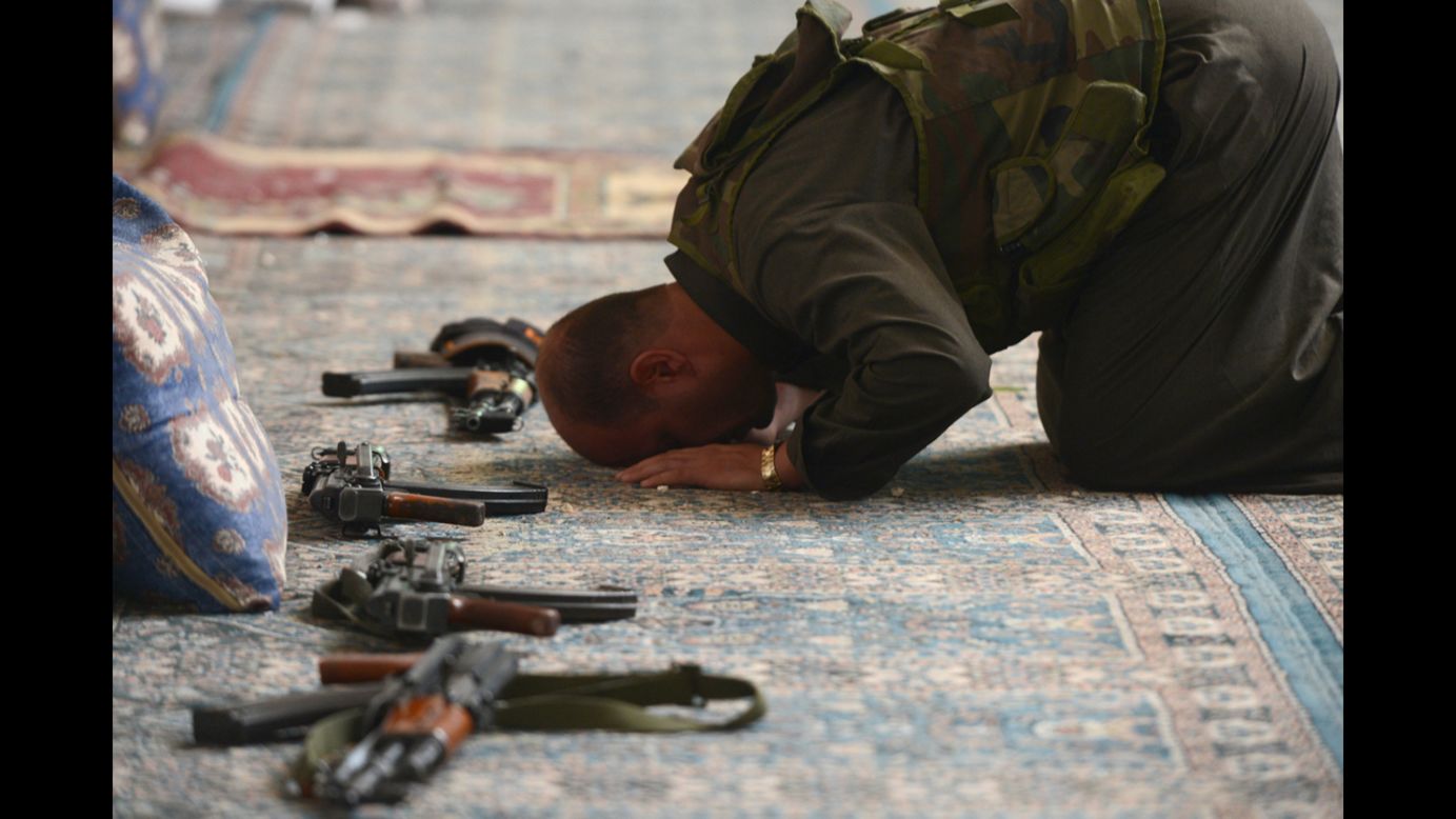 A Syrian rebel commander prays in a damaged mosque during clashes with government forces on Tuesday in Aleppo.