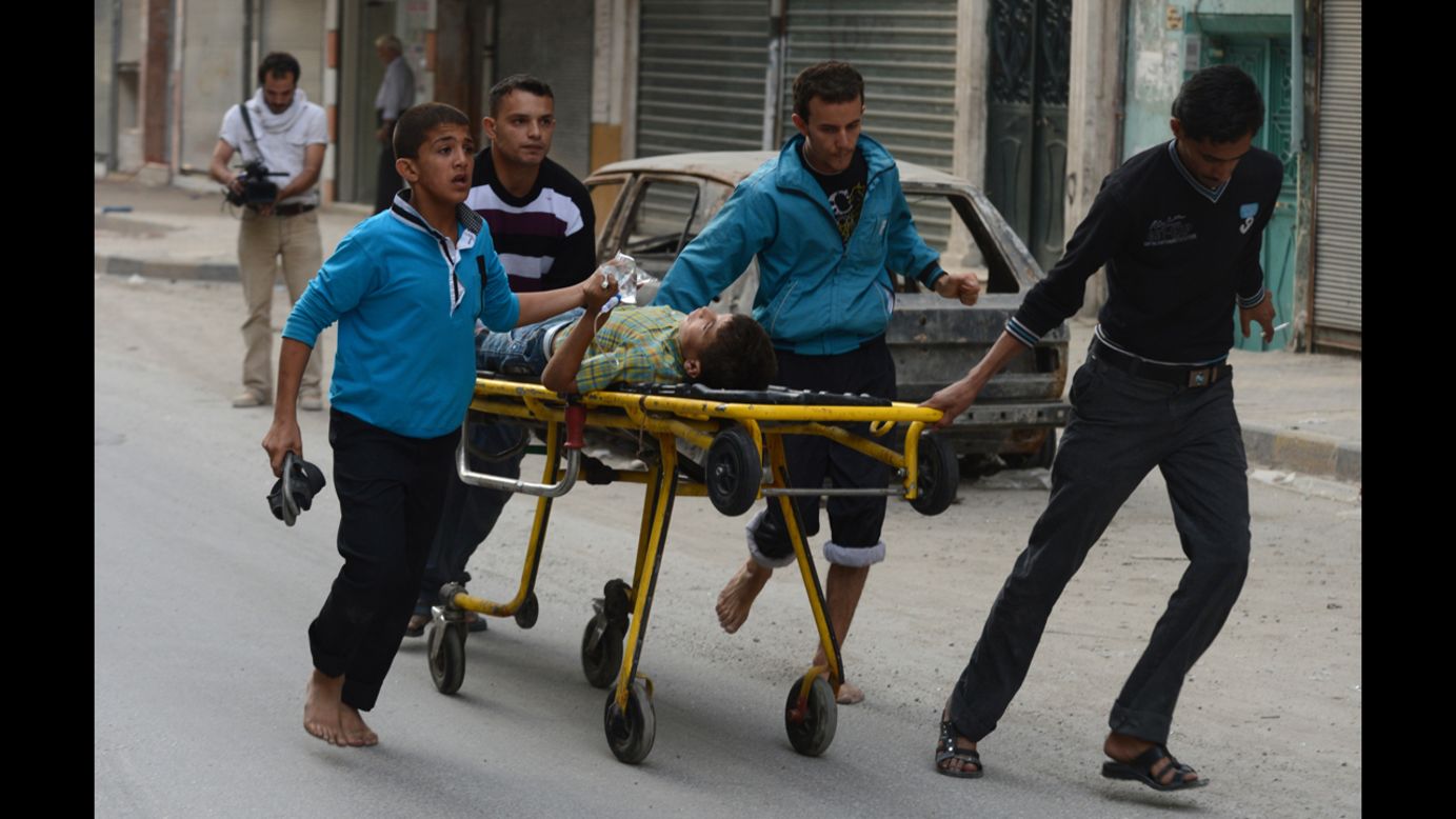 Relatives wheel a injured boy outside a hospital on Tuesday in Aleppo.