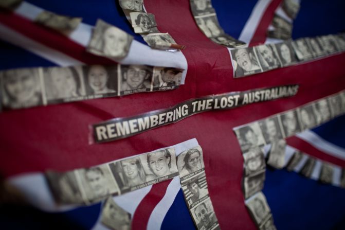 An Australian flag tied to a fence near the site of the blasts carries the photos of the 88 Australian victims of the attack. 