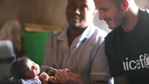 David Beckham touches the hand of two-day-old Mariatsu during a visit to the newborn's home in Sierra Leone.