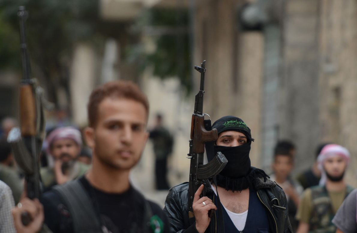 Syrian opposition fighters walk in the streets of Aleppo on Thursday.
