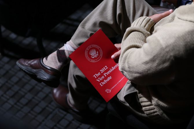 An audience member holds a debate program.