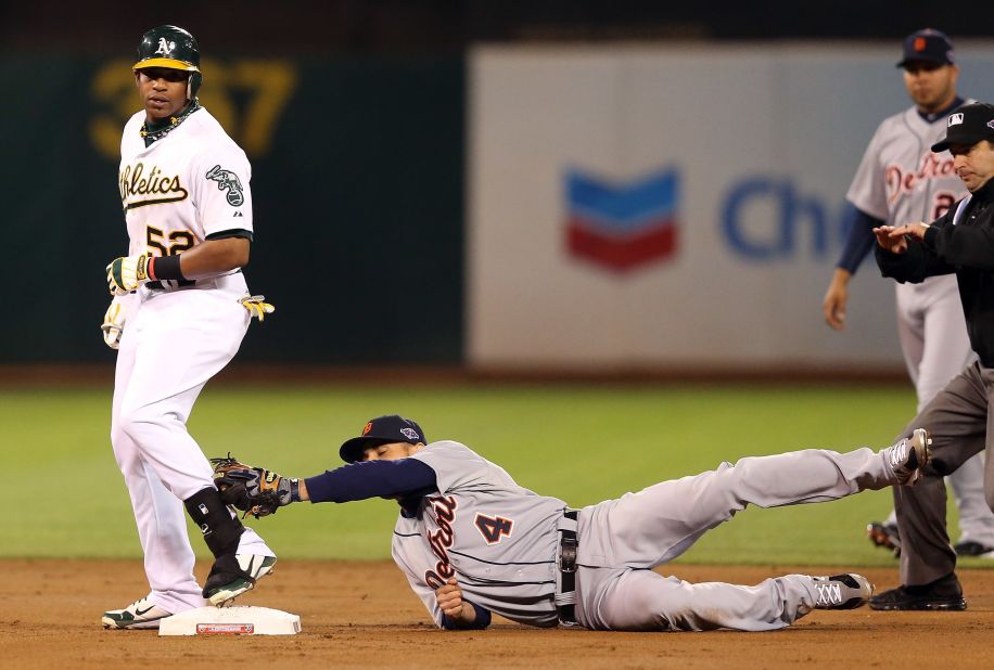 Yoenis Cespedes of the Oakland Athletics beats a tag by Omar Infante of the Detroit Tigers for a double in the first inning in Game Five of the American League Division Series Thursday at O.co Coliseum in Oakland, California.