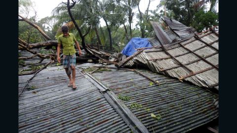 A Bangladeshi resident walks over the destroyed roof of a building on Bhola island on Thursday.