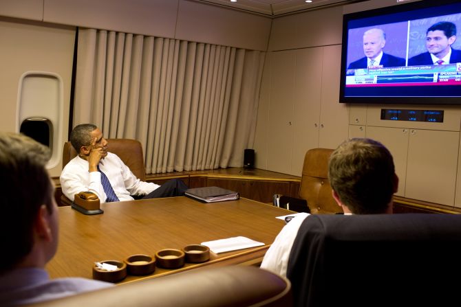 President Barack Obama watches the vice presidential debate aboard Air Force One with staff while heading home from Florida on Thursday.