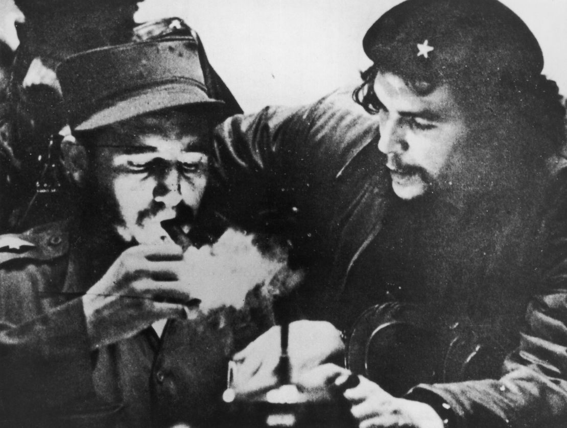 Fidel Castro lights his cigar while Argentine revolutionary Che Guevara looks on in the early days of their guerrilla campaign in the Sierra Maestra Mountains of Cuba, circa 1956.