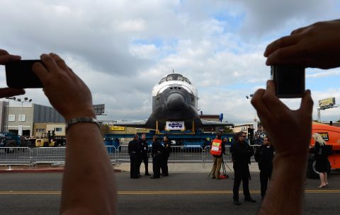 Spectators take pictures of Endeavour during its journey through Los Angeles.