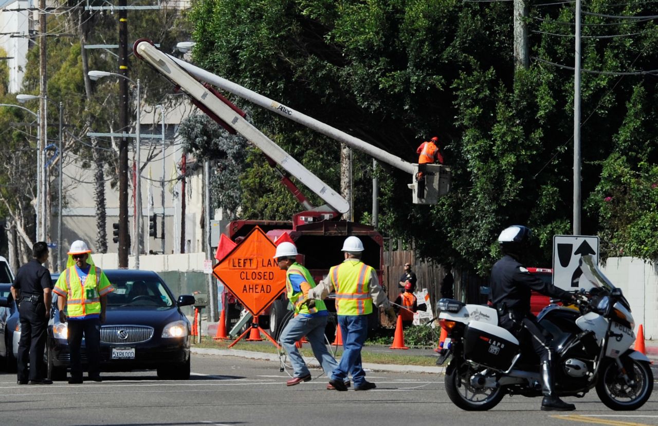 Tree trimmers cut large branches of a tree that was protruding toward the street in a last-minute effort to clear hurdles along the space shuttle Endeavour's route on Friday.