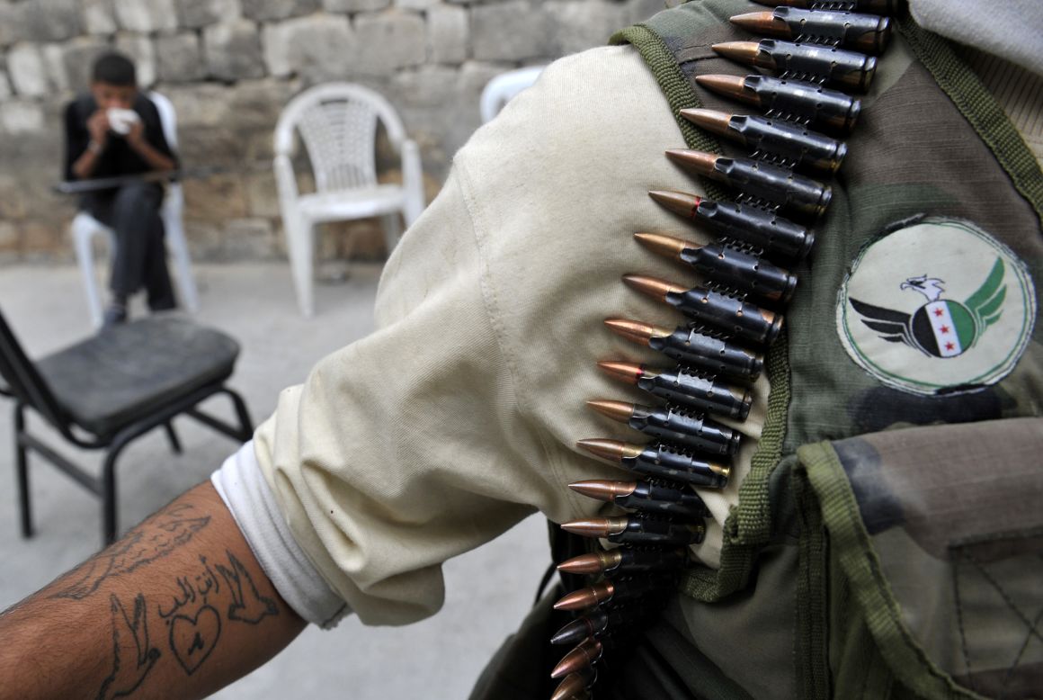 A heavily armed Syrian opposition fighter stands near a post in Aleppo on Thursday.