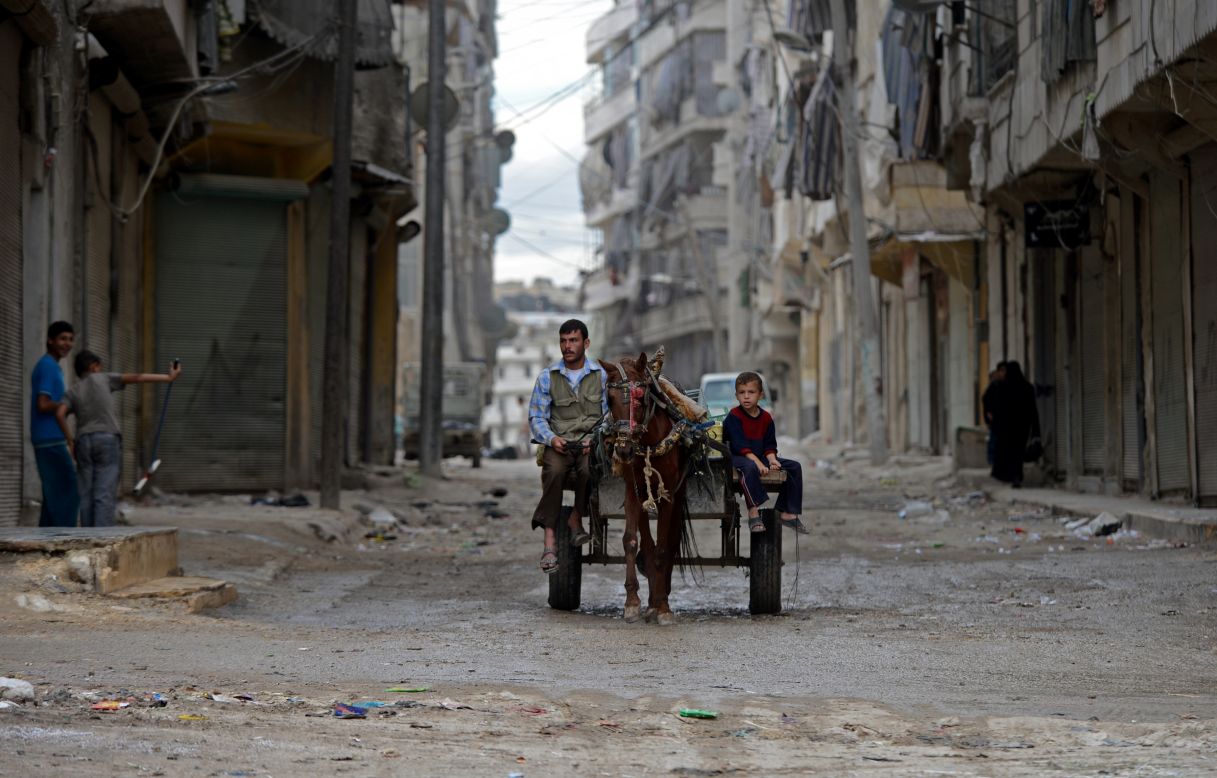 A Syrian man and boy ride a horse cart in Aleppo on Thursday.