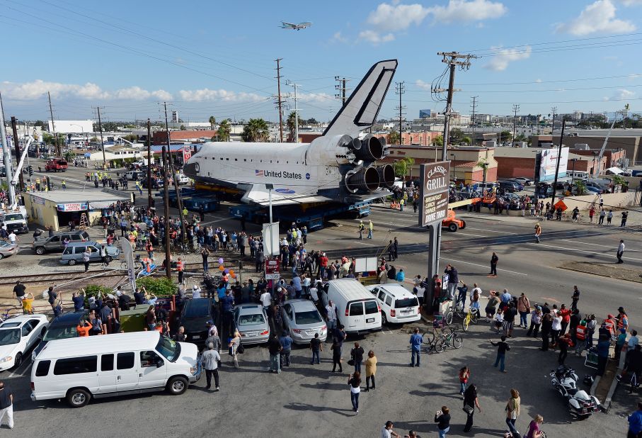 Endeavour moves down a main road lined with onlookers. Endeavour was flown cross-country atop NASA's Shuttle Carrier Aircraft from Kennedy Space Center in Florida to LAX on September 21.