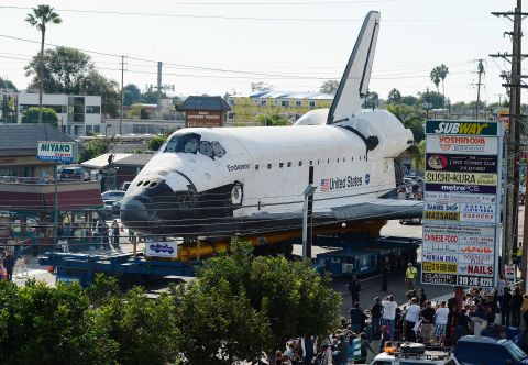 Endeavour makes its way past restaurants and shopping centers in Los Angeles.