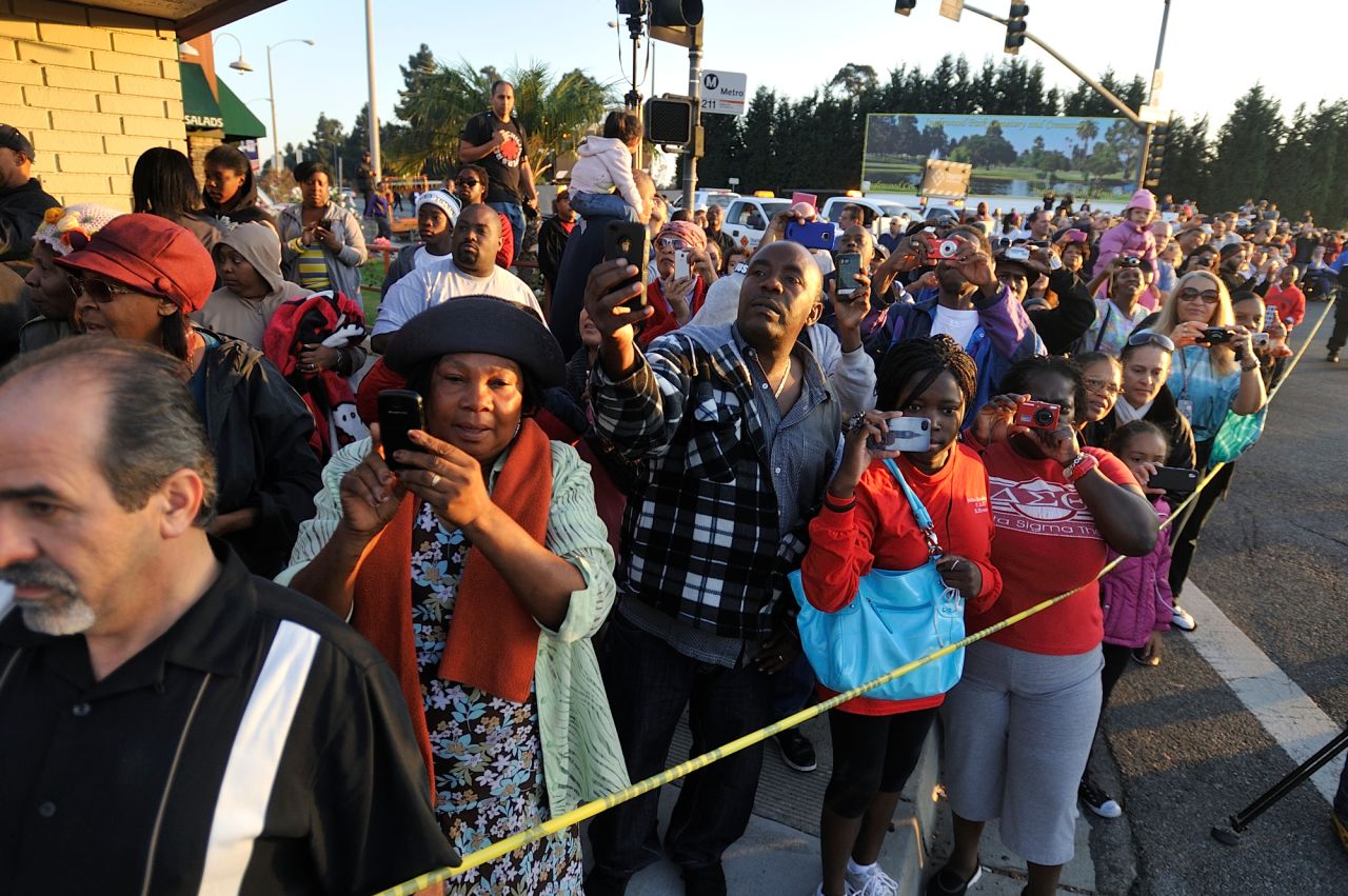 People watch as the space shuttle slowly moves along Manchester Boulevard in Inglewood on Saturday.