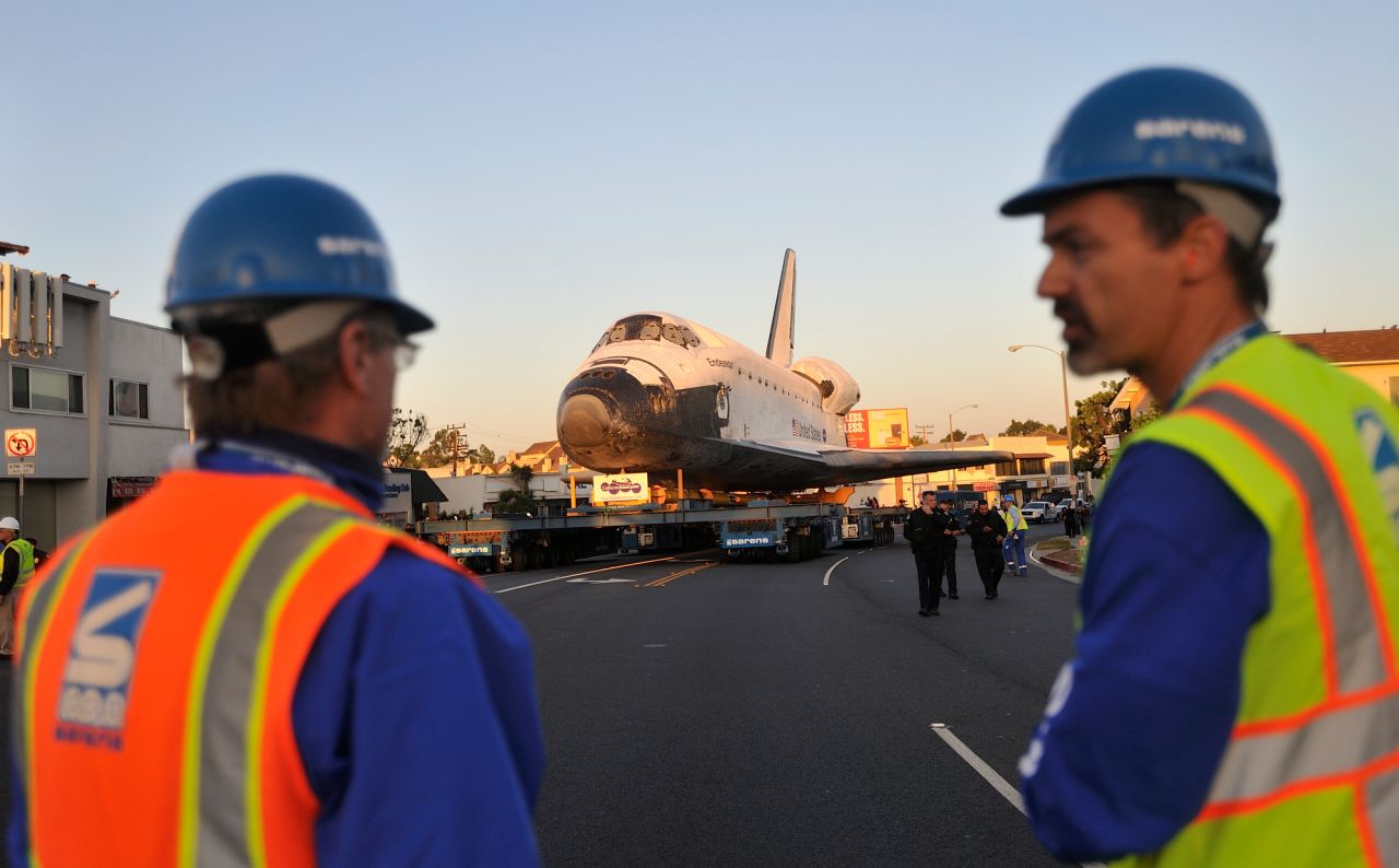 Workers talk as the shuttle moves along Manchester Boulevard on Saturday.